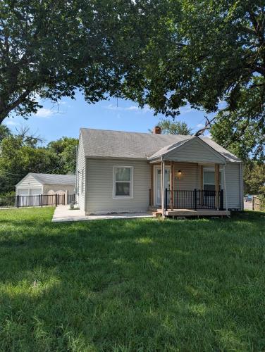 a white house with a porch and a yard at Zoobilee-on Zoo Blvd in Wichita