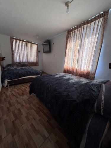 a bedroom with two beds and two windows at Casa Campo con piscina, billar, casa árbol, y huerta a 10 minutos de la FIA in Socabaya