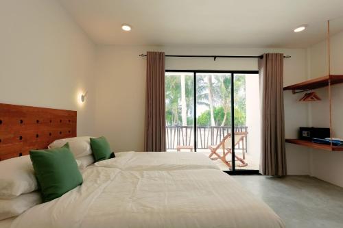 a bedroom with a large bed and a balcony at Azul Retreat in Dhigurah