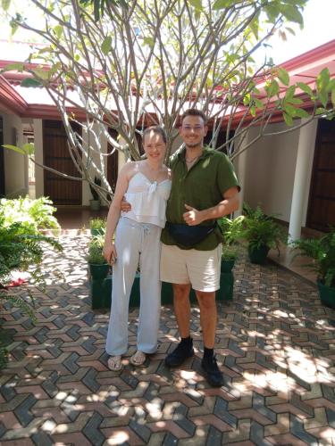 a man and a woman standing in front of a tree at EverGreen Resort Udawalawe in Udawalawe