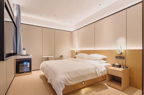 Ένα ή περισσότερα κρεβάτια σε δωμάτιο στο Dayin Hotel -Shanghai Hongqiao Beixinjing Metro Station Branch -Large Social Area -Bar -Café -Gym -Free Laundry Luggage Storage -24H Front Desk-English Service