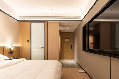Ένα ή περισσότερα κρεβάτια σε δωμάτιο στο Dayin Hotel -Shanghai Hongqiao Beixinjing Metro Station Branch -Large Social Area -Bar -Café -Gym -Free Laundry Luggage Storage -24H Front Desk-English Service