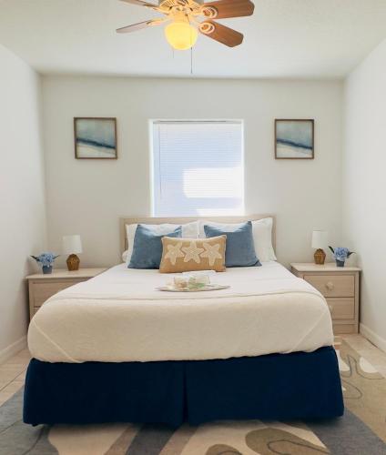 a bedroom with a large bed with a ceiling fan at Steps to the Sand - Private Beach Access & BBQ Grill in Indialantic