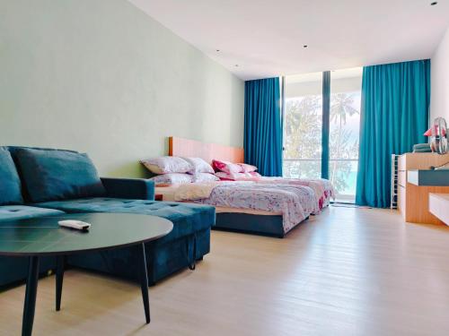 a bedroom with a bed and a couch and a table at Sematan Roxy Beach Apartment in Sematan