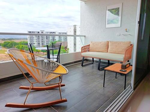 a balcony with a couch and chairs on a balcony at Condominio Ricaurte in Ricaurte