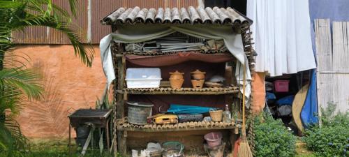 a shelf with pots and other items on it at ตั้วบ้านดิน Tuabaandin in Ban Thung Phan Ha