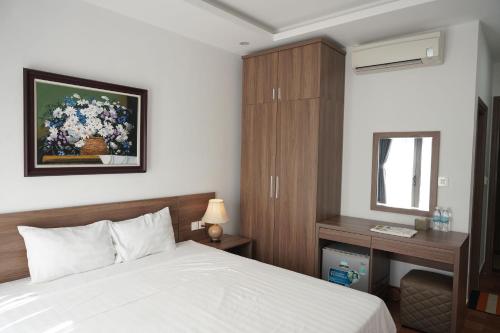 a bedroom with a bed and a desk and a mirror at Cam Ranh Surf Home in Cam Lâm