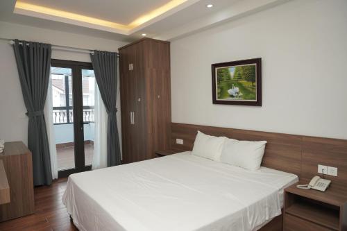a hotel room with a bed and a phone at Cam Ranh Surf Home in Cam Lâm