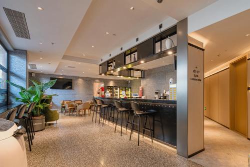 a bar in a restaurant with stools at Dayin Hotel -Shanghai Hongqiao Beixinjing Metro Station Branch -Large Social Area -Bar -Café -Gym -Free Laundry Luggage Storage -24H Front Desk-English Service in Shanghai