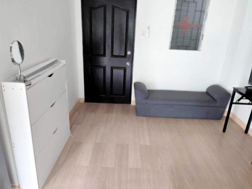 a room with a blue couch and a black door at Prime City Location - 3 Bedroom Unit in Lapu Lapu City