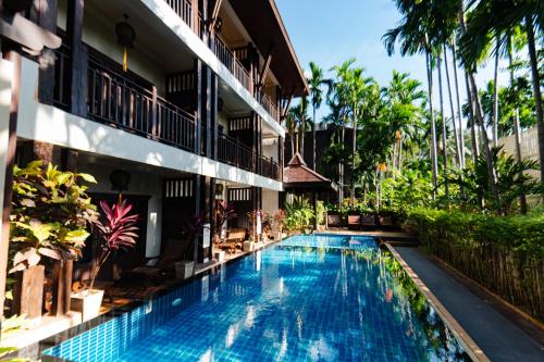 a swimming pool in front of a building at Viang Thapae Resort in Chiang Mai