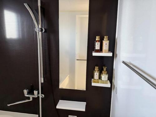 Shidoにあるアラハブルーリゾート901の鏡と洗面台付きのシャワーを備えたバスルーム