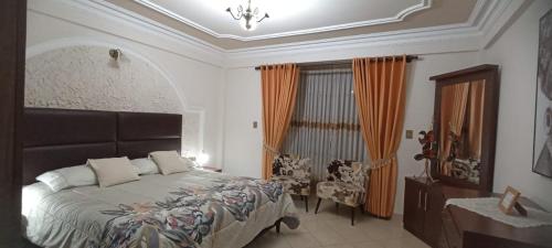 a bedroom with a bed and a chair and a window at Como en casa para familia con niños in Sucre