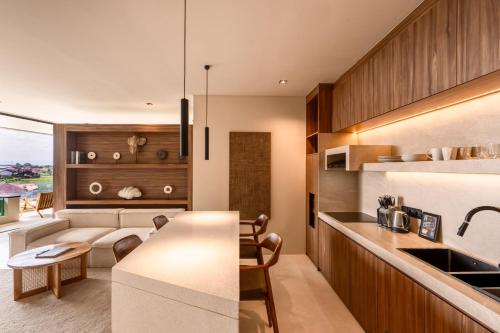 a kitchen and living room with a couch and a table at Sore Escape Tumbak Bayuh by Betterplace in Tumbak Bayuh