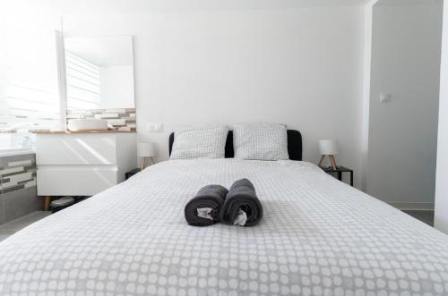 a bed with a pair of slippers on it at Welcome Home in Vert-le-Grand