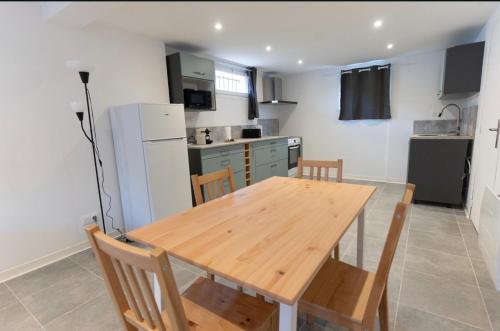 a kitchen with a wooden table and chairs at Welcome Home in Vert-le-Grand