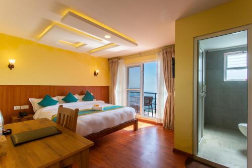 a bedroom with a bed and a table and a bathroom at Naikap Village Resort Pvt in Kathmandu