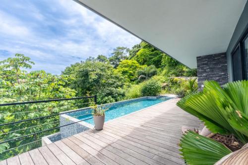 a house with a swimming pool on a wooden deck at Villa with Stunning Isla Tortuga Ocean View, Near Curu Park & Ferry in Blue Zone in Paquera