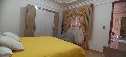 a bedroom with a yellow bed and a chair at Como en casa para familia con niños in Sucre