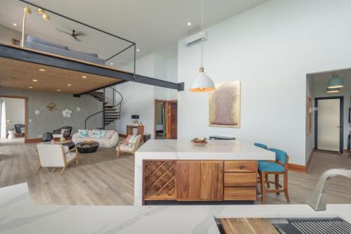 a kitchen and living room with a loft at Villa with Stunning Isla Tortuga Ocean View, Near Curu Park & Ferry in Blue Zone in Paquera