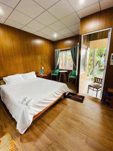 a bedroom with a large bed and a wooden wall at Châu Homestay in Thôn Dương Xuân Hạ