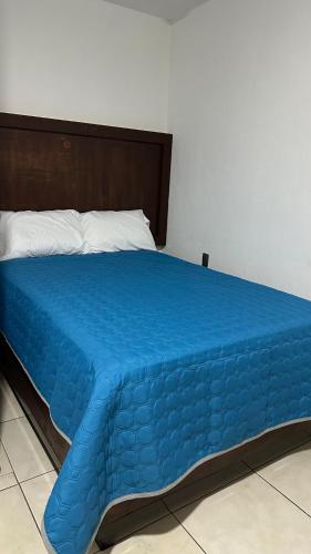 a blue bed with a blue comforter on it at CASA BRAVO in Huamantla