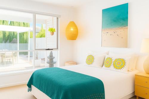 a white bedroom with a bed and a window at Bundalong River Retreat & Poolside Bliss in Bundalong