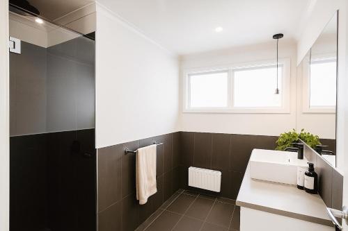 une salle de bain avec un lavabo et un miroir dans l'établissement Bundalong River Retreat & Poolside Bliss, à Bundalong