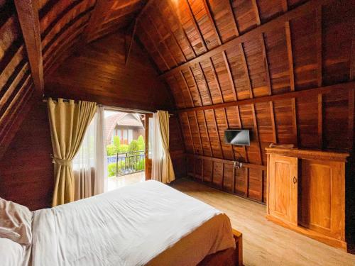a bedroom with a bed in a room with a window at Lilis Aksito Akusara by Lavana in Canggu