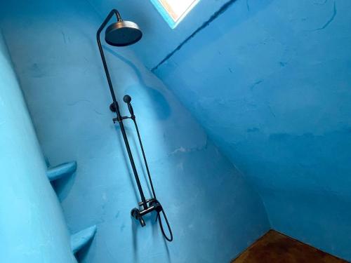 a shower in a room with a blue wall at Ecostay Glamping Rainbow Forest in Ishigaki Island