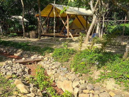 a gazebo with a pile of rocks in a yard at Ecostay Glamping Rainbow Forest in Ishigaki Island