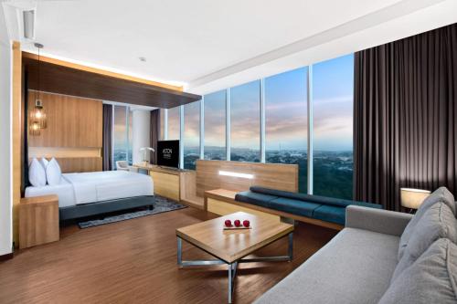 a hotel room with a bed and a living room at Aston Sidoarjo City Hotel & Conference Center in Sidoarjo