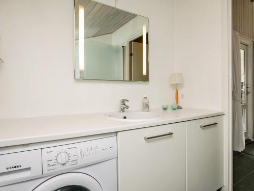 a white bathroom with a sink and a mirror at 6 person holiday home in Blokhus in Blokhus