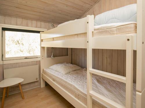 a bunk bed in a room with a desk and a chair at 6 person holiday home in Blokhus in Blokhus