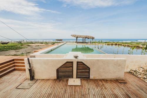 a pool on a deck with the ocean in the background at ITACA Ecolodge Home 
