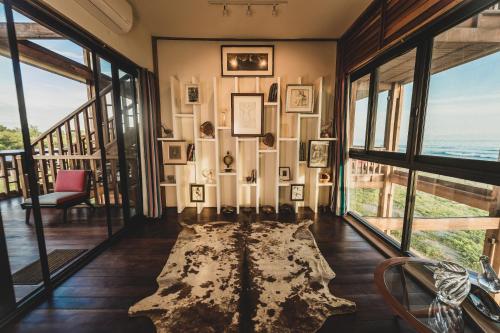 a living room with windows and a rug on the floor at ITACA Ecolodge Home 