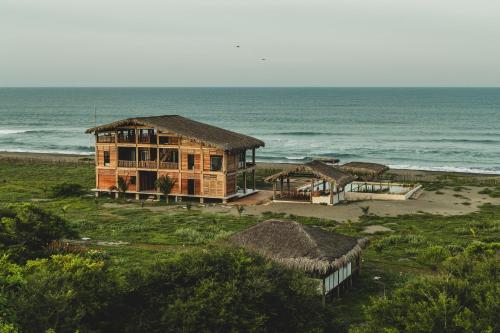 a house on the beach with the ocean in the background at ITACA Ecolodge Home 