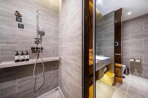 a bathroom with a shower and a sink at Atour Hotel Shunde Midea Yueran Plaza Foshan in Shunde