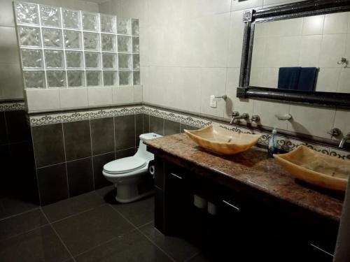 a bathroom with two sinks and a toilet and a mirror at Paradise by the Playa in Los Ayala
