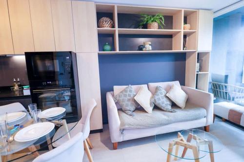 a living room with a couch and a table at HOM I 2D2B Parking, piscina temperada y gimnasio in Puerto Varas