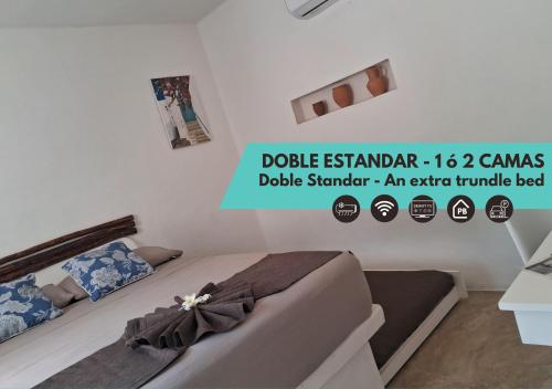 a bedroom with two beds and a sign that says dole esplanara at Hotel Posada Mykonos in Bacalar
