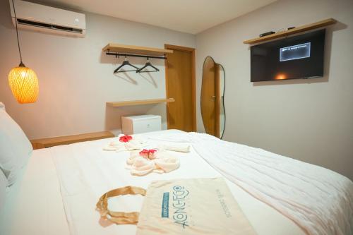 a bedroom with a bed with towels on it at Pousada Aconchego Noronha in Fernando de Noronha