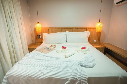 a bedroom with a bed with two ducks on it at Pousada Aconchego Noronha in Fernando de Noronha