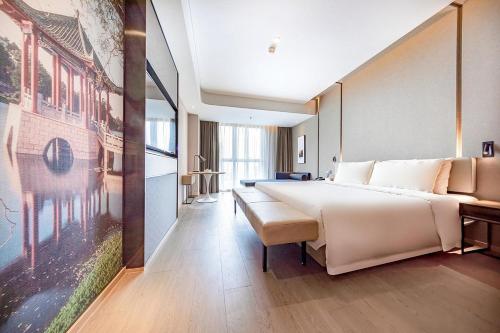 a bedroom with a large bed and a large painting at Atour Hotel Shunde Midea Yueran Plaza Foshan in Shunde