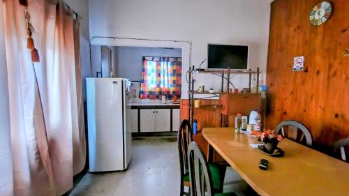a kitchen with a table and a white refrigerator at Casa céntrica Yrigoyen in Santa Rosa