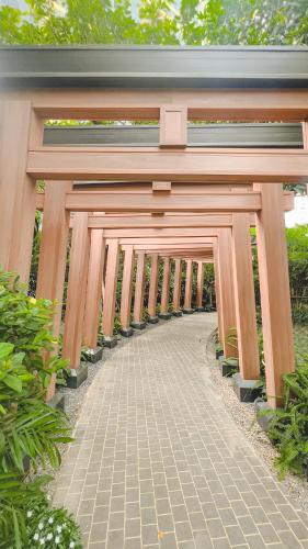 a wooden gate with a walkway in a garden at Lynn Times Thanh Thuy Onsen Hot Spring in La Phu