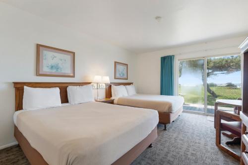 a hotel room with two beds and a window at Crescent Beach Motel in Crescent City