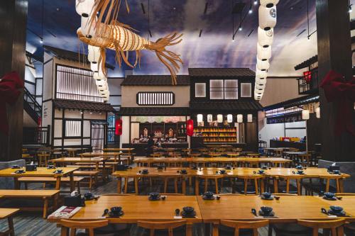 a restaurant with wooden tables and a fish hanging from the ceiling at Lynn Times Thanh Thuy Onsen Hot Spring in La Phu