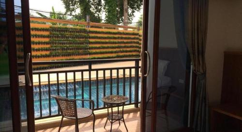 a balcony with a table and chairs and a swimming pool at The Green Hotel in Ko Lipe