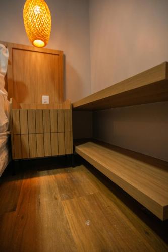 a room with wooden bunk beds and a light at Pousada Aconchego Noronha in Fernando de Noronha